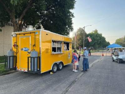 people eating food outside of yellow food truck